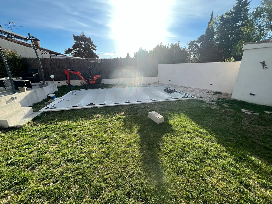 Préparation du terrain autour de la piscine, mini-pelle au fond du jardin