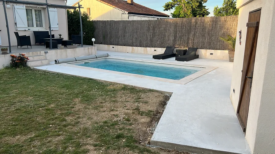 Plage claire autour de la piscine menant au pool house