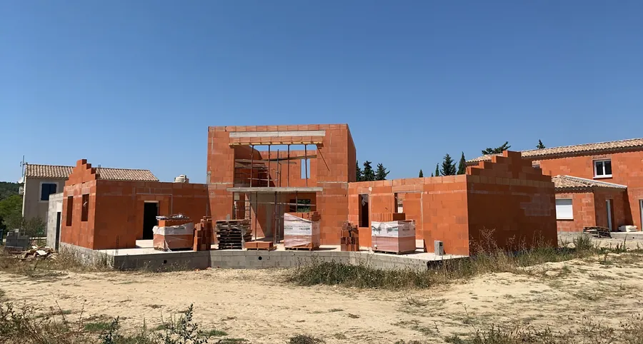 Maison en brique avec les murs de l’étage en cours de construction à Sazé