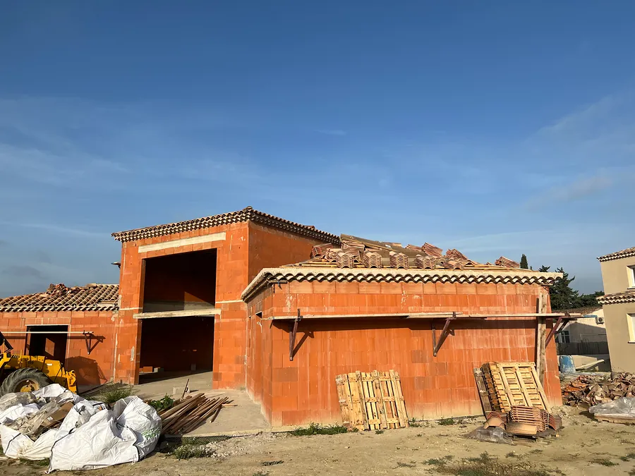 Maison en brique de terre cuite couverte en tuiles, avec une partie centrale à étage