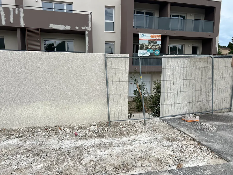 Mur de clôture enduit le long du parking